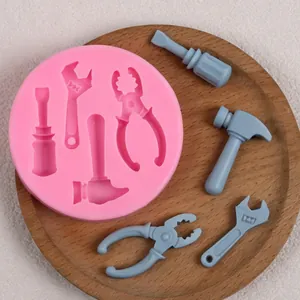 Vue détaillée d'un moule en silicone rose avec des formes d'outils comme marteaux et clés.