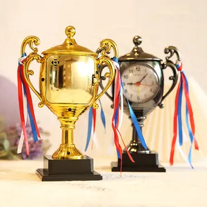 Creative trophy-shaped alarm clocks in gold and black with ribbons, perfect for student gifts.