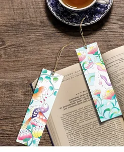 Close-up of portable watercolor bookmarks with unicorn and floral patterns on an open book