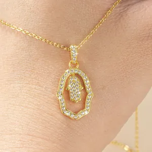 Close-up of gold Hamsa Hand pendant necklace with sparkling micro-pavé stones