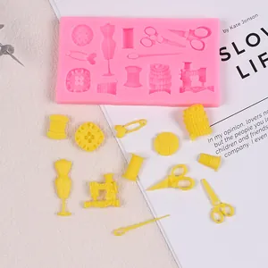 Close-up of pink silicone sewing theme mold with yellow fondant scissors and buttons