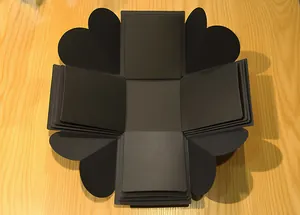 Vista abierta de una caja de regalo negra multicapa DIY para un álbum de fotos único