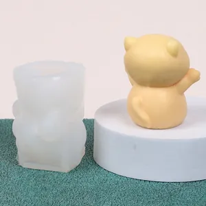 Detailed view of cat-shaped silicone mold with finished yellow cat candle ornament