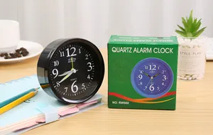 Detailed view of a simple black quartz alarm clock with its green retail packaging.