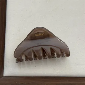 Detailed view of a semi-transparent brown triangle hair claw clip with strong grip