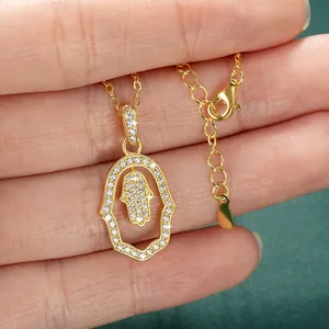Close-up view of a gold-filled Hamsa Hand necklace with shimmering clear crystals