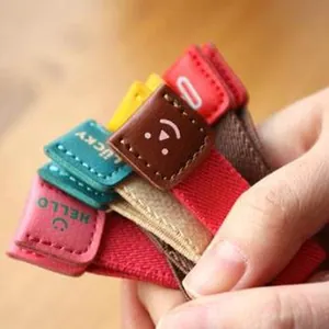 Set van schattige kleurrijke lederen kabelorganisatoren met smileys en elastiekjes.