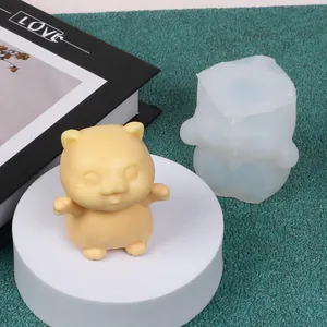 Detail view of cute animal-shaped silicone mold and a finished yellow wax cat candle