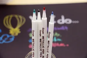 Close-up detail of GuangNa metallic markers showing different colored nibs and white barrels