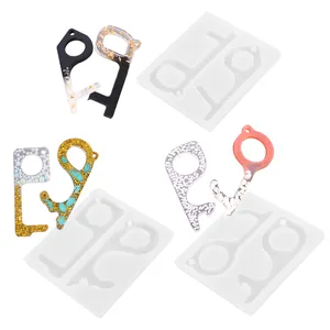 Detail showing silicone molds and finished resin no-touch door opener elevator tool keychains