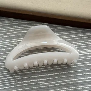 A detailed view showing the glossy cream translucent finish of this hair claw clip.