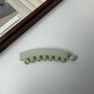 Detailweergave van een pastelgroene banaan haarklem met tanden voor haarstyling