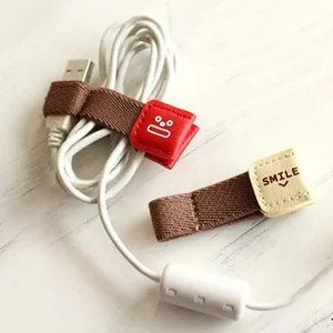 Schattige lederen kabelorganizer met smile gezicht voor oortelefoon en USB-kabels