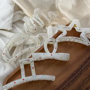Elegant white marble hair claws set with colorful rhinestones in star and bow shapes