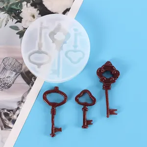 Close-up of silicone mold for resin door opener keys and finished burgundy resin pieces