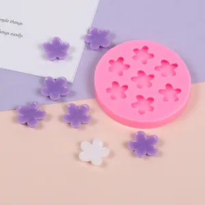 Detail shot of pink silicone flower mold with finished purple and white resin flowers