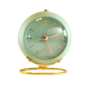 Minimalist mint green spherical analog table clock with an elegant gold metal stand