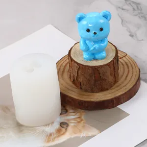 Vue détaillée du moule en silicone ours à côté d'une figurine de bougie bleue finie