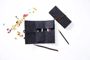 Dettaglio di un portapenne in feltro nero arrotolabile con decorazioni colorate