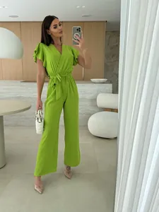 Vibrant lime green V-neck jumpsuit with ruffled sleeves and belted wide leg details.
