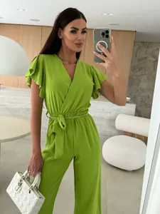 Detail view of a stylish lime green V-neck jumpsuit with ruffled sleeves and tie waist.