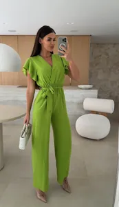 Detail of a chic lime green V-neck jumpsuit with short sleeves and a belted waist.