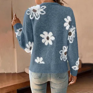 Back view of a cozy blue knit cardigan sweater featuring large white daisy floral patterns