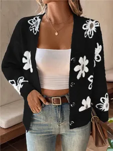 Close-up of a black knit cardigan featuring fuzzy white flower patterns and buttons