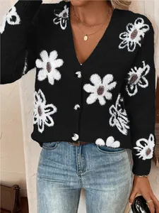 Close-up of stylish black knitted cardigan featuring white daisy floral patterns