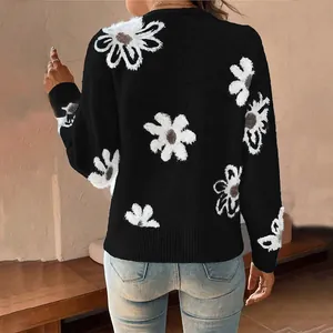 Back view of a cozy black knit cardigan featuring bold white daisy floral embroidery detail.