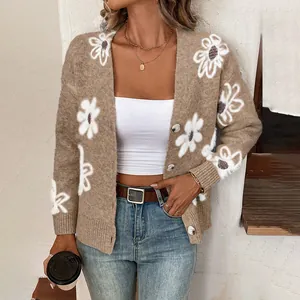 Detail of a brown knitted cardigan with white daisy flower patterns and buttons