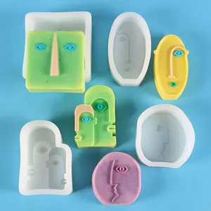 Detailed view of abstract face silicone molds and finished DIY plaster ornaments.