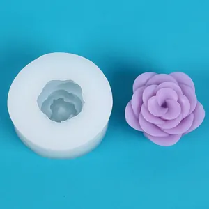 Primo piano dettagliato di uno stampo in silicone rosa 3D accanto a un fiore di sapone viola