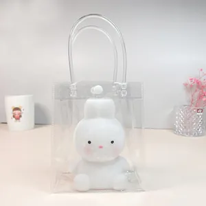 Transparante PVC geschenkverpakking met een schattig wit konijnennachtlampje op een bureau