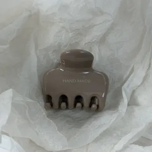 Detailopname van een minimalistische kaki glanzende grote haarklem haarklip