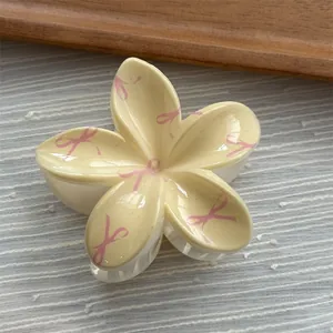 Detailed view of flower hair claw clip with pink ribbon pattern