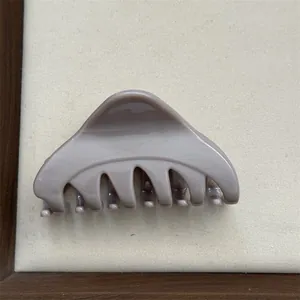 Detailed close-up of a minimalist taupe medium Korean triangle hair claw clip