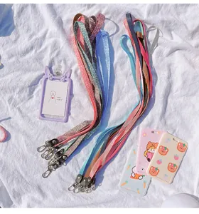 Detailed view of colorful lanyards and cute cartoon ID card holders with metal hooks.