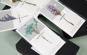 Detailed view of handmade greeting cards featuring real dried flowers
