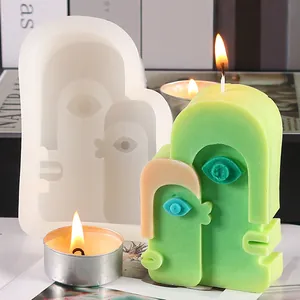 Detailed view of creative abstract face silicone mold with its finished green candle piece
