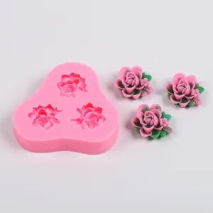Détail du moule en silicone rose à 3 cavités avec fleurs en résine terminées.