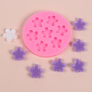 Detailed view of pink silicone mold with flower-shaped cavities and resin pieces