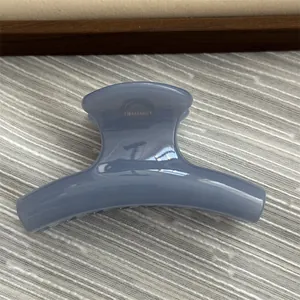 Close-up detail of a small jelly blue curved hair claw clip for elegant styling