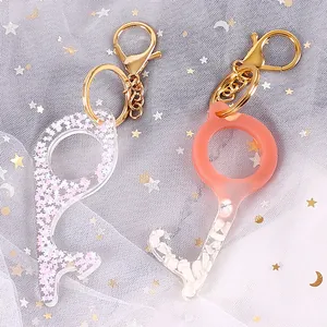 Close-up of DIY resin no-touch keychains featuring star glitter and white stone inlays.