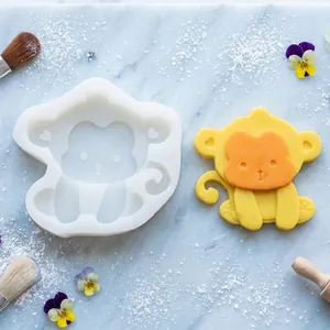 Molde de silicona con forma de mono y una figura amarilla para repostería o manualidades.