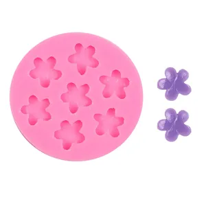 Close-up of pink five-petal flower silicone mold with purple resin samples