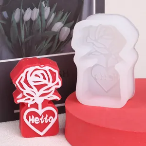 Close-up of silicone mold and finished red rose heart candle featuring 'Hello' engraving