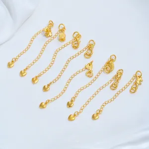 Close-up detail of 24K gold plated jewelry extender chains with various artistic charms