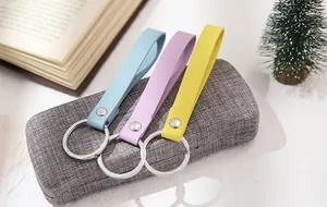 Minimalist colorful PU leather keychains with metal rings in blue, pink, and yellow.