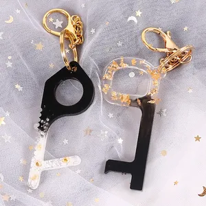 Close-up of handmade resin no-touch door opener keychains with gold foil accents